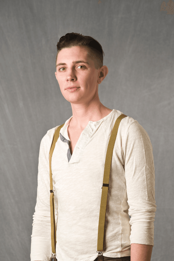 A slender, transgender man modeling his gender affirming short, masculine haircut by Bianca Marie Brookman.