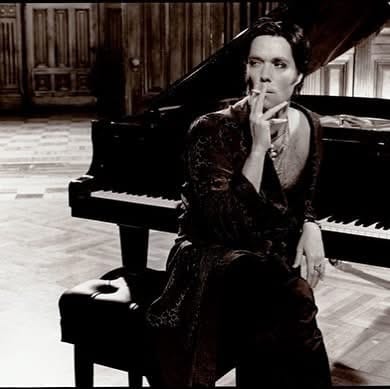 Black and white Photograph of a man sitting at a grand piano smoking a cigarette by Kevin Westenberg once displayed at Aria Salon for Capitol Hill Art Walk, Seattle. 