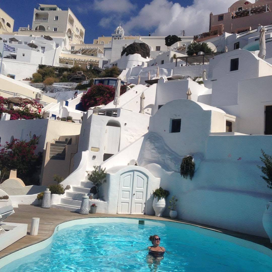 Bianca Marie Brookman | Greece Pool Photo of Bianca Brookman in a pool surrounded by white washed Grecian buildings.