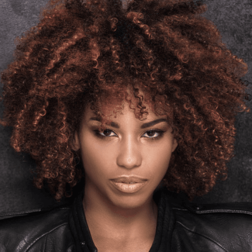 African American woman with dimensional red and auburn color by Bianca Marie Brookman of Aria Salon.